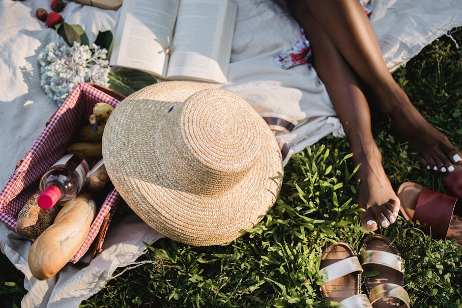 A relaxing summer picnic scene with a straw hat and open book on a blanket.