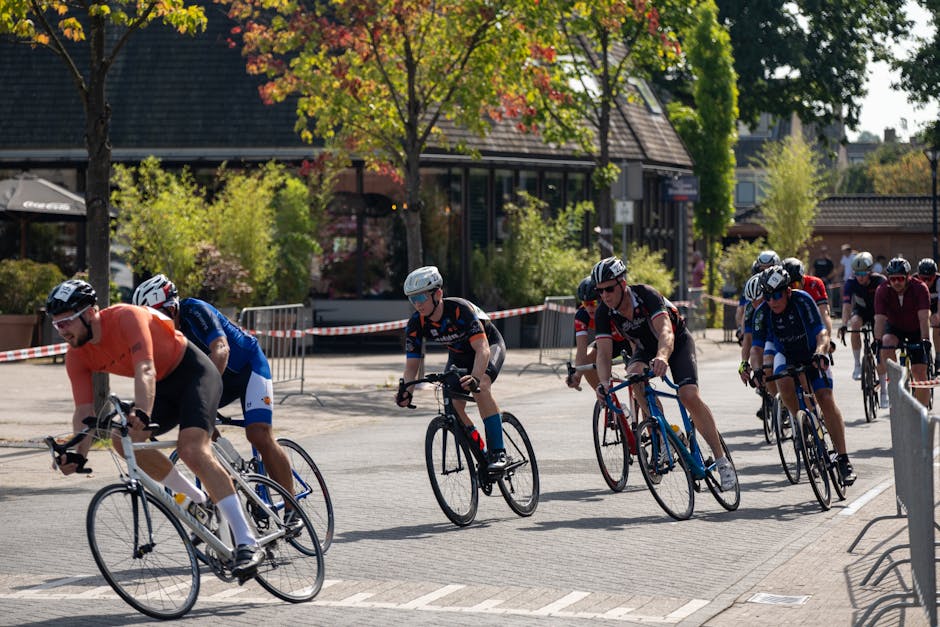 Adult men cycling in a competitive street race under sunny skies.
