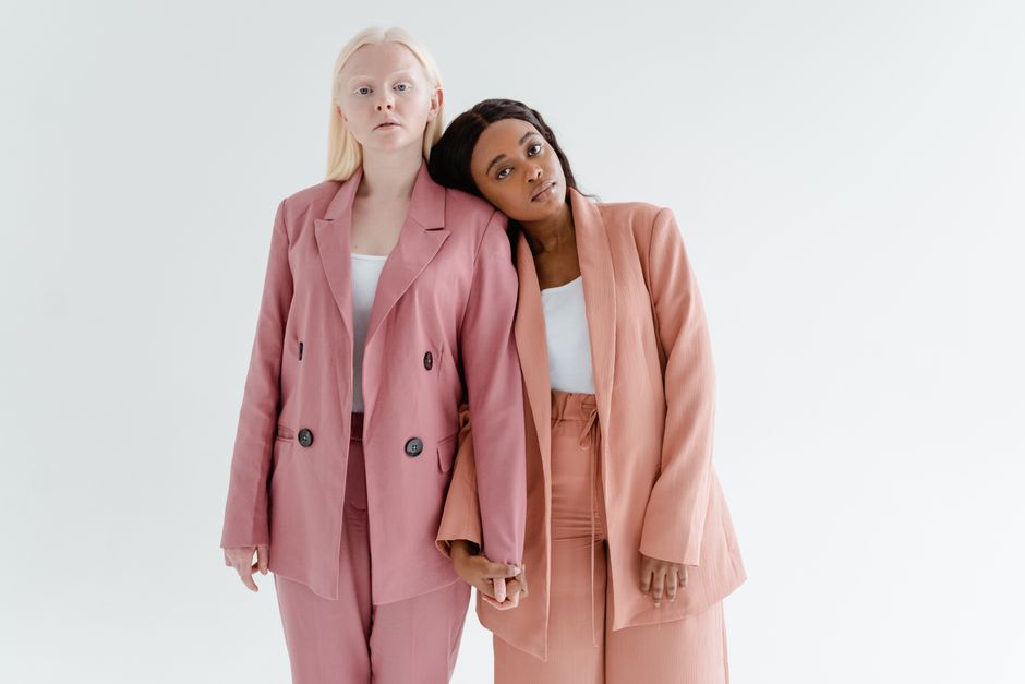 Two women in stylish blazers stand in solidarity, exemplifying unity and empowerment.