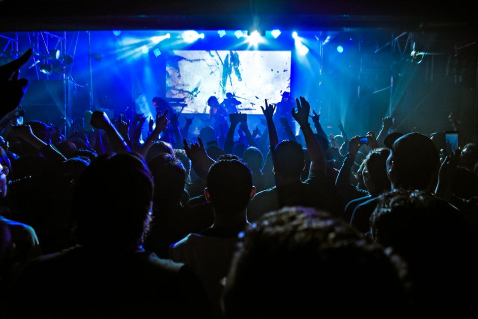 Crowd enjoying a dynamic live concert performance with vibrant lights in Guadalajara.