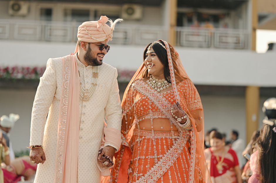 Happy Indian bride and groom in vibrant traditional attire on their wedding day.