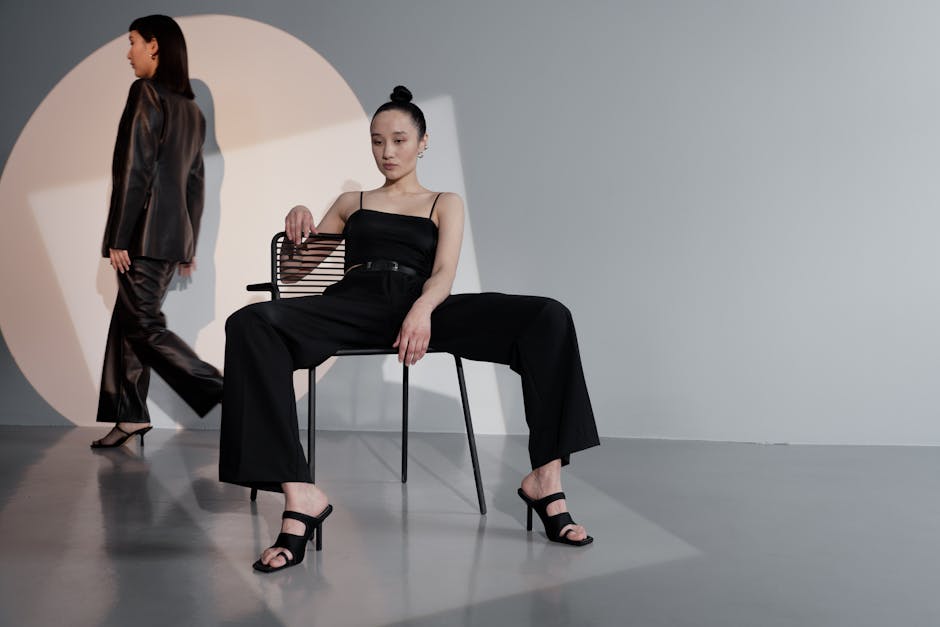Modern studio shoot featuring stylish Asian women in black outfits, highlighting fashion and poise.