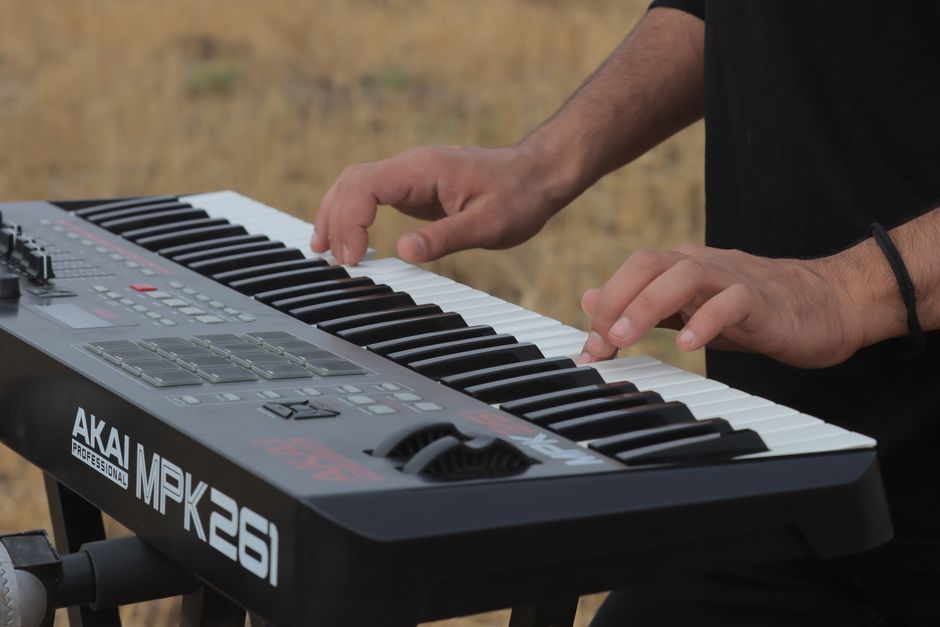 Close-up of a musician playing a keyboard outdoors in Qazvin Province, Iran.