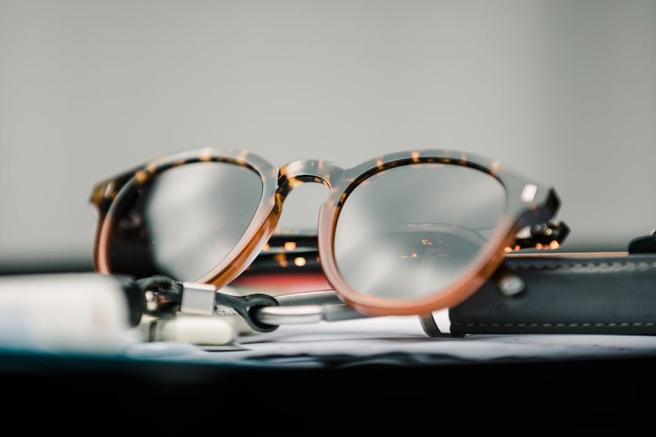 Close-up of fashionable tortoiseshell sunglasses resting on a desk.
